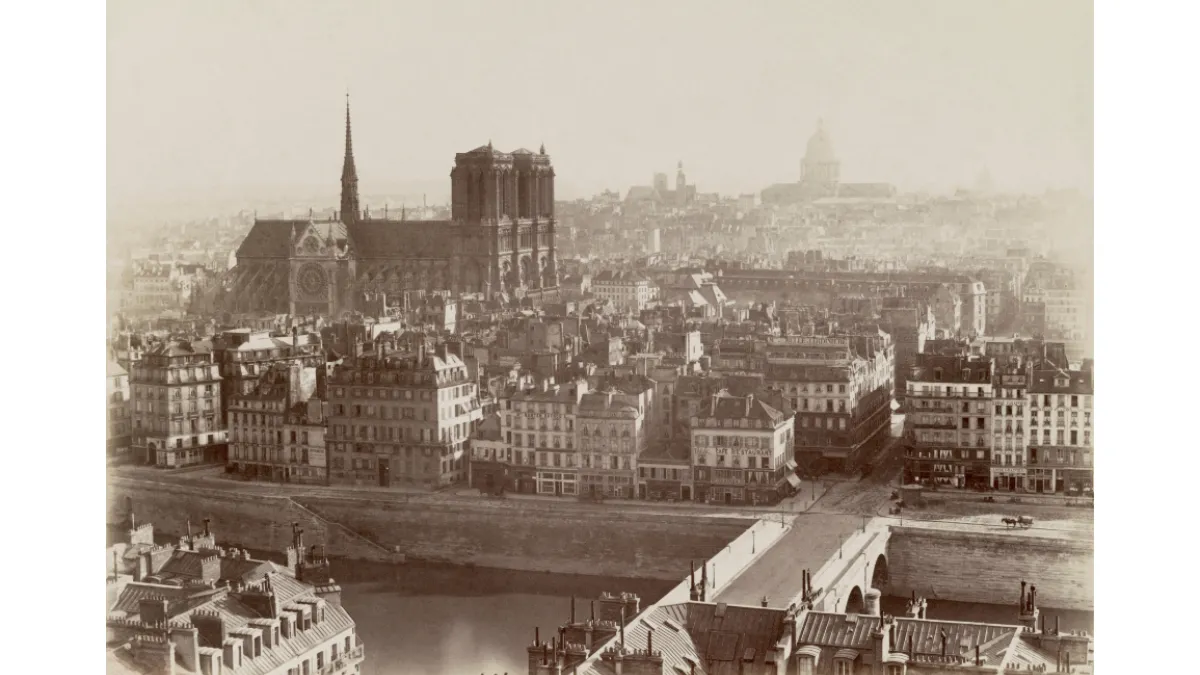 Photograph shows view of Notre-Dame de Paris rising above Ile de la Cité.