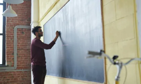 Man writing on a chalkboard