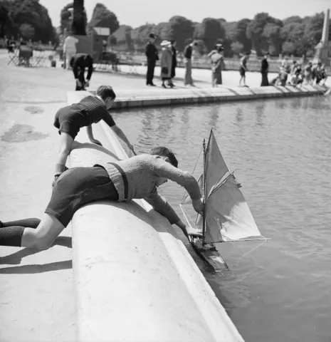 kids playing in water with sailboats