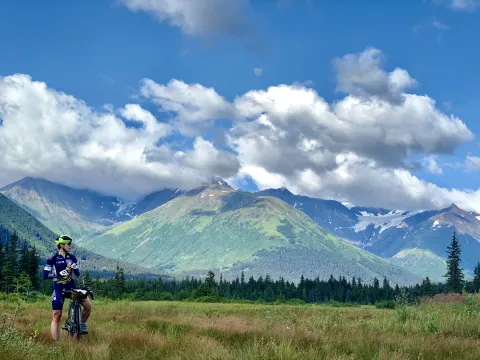 Kristen Faulkner outside taking a break from riding on her bike to take in the landscape of Alaska.