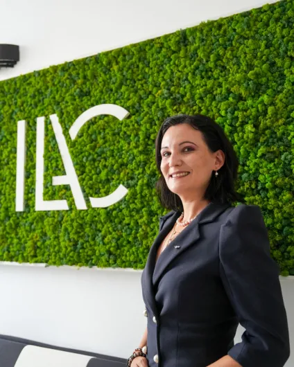 Photo of Ginka HRISTOVA in front of her organization's ILAC signage.